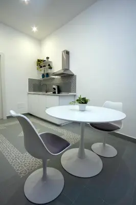 a white table and two chairs in a kitchen at Cortile Del Greco Apartments in Palermo