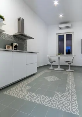 a kitchen with white cabinets and a table at Cortile Del Greco Apartments in Palermo