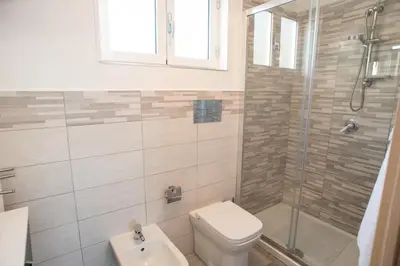 a bathroom with a toilet and a shower and a sink at Appartamento con terrazza in Isola delle Femmine