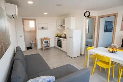 a living room and kitchen with a couch and a table at Appartamento con terrazza in Isola delle Femmine