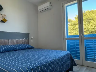 a room with a desk with a television on a wall at Cala Azzurra Macari in Macari