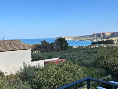 a bedroom with a large bed with a blue headboard at Cala Azzurra Macari in Macari