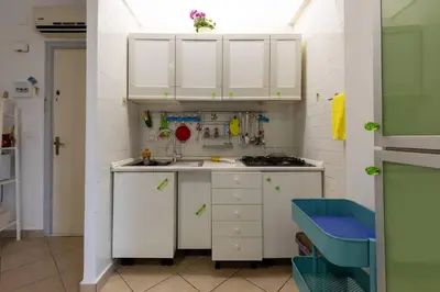 a small kitchen with white cabinets and a sink at Isola delle Femmine Holiday Nancy in Isola delle Femmine