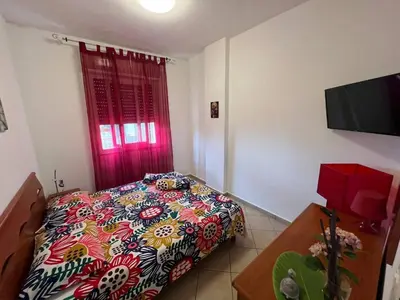 a bedroom with a bed and a red window at Isola delle Femmine Holiday Nancy in Isola delle Femmine