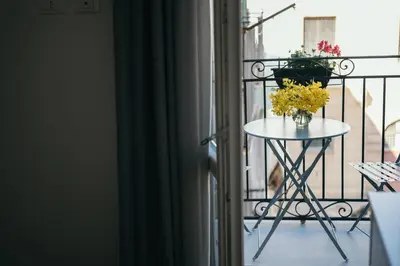 a table with a vase of flowers on a balcony at La Casa di Ale in Palermo