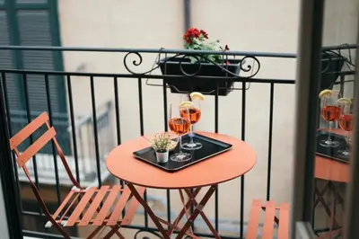 a table with two glasses of wine on a balcony at La Casa di Ale in Palermo