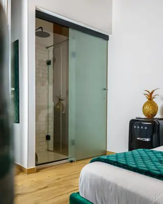 a bedroom with a glass door with a shower at Curtigghiu Mondello in Mondello