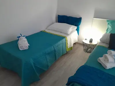 a bedroom with two beds with towels on them at Sea Holiday Orchidea in Palermo