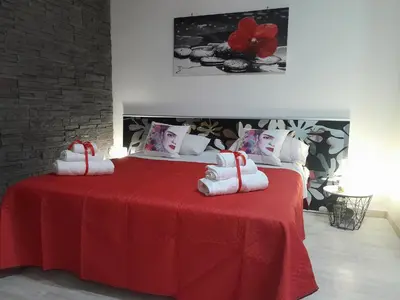 a bedroom with a red bed with towels on it at Sea Holiday Orchidea in Palermo