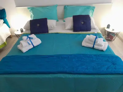 a large bed with blue sheets and towels on it at Sea Holiday Orchidea in Palermo
