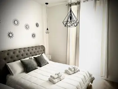 a bedroom with a large white bed with towels on it at Affittacamere Palermo Pirri in Palermo