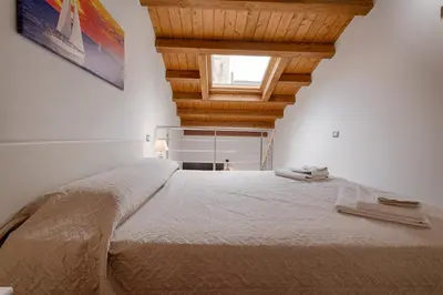 a bedroom with a large bed with a wooden ceiling at GuestHost - Il Piccolo Scrigno - Functional & Central Studio in Castellammare del Golfo