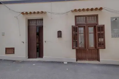 a white building with two doors and windows at GuestHost - Il Piccolo Scrigno - Functional & Central Studio in Castellammare del Golfo
