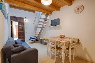 a living room with a table and a clock on the wall at GuestHost - Il Piccolo Scrigno - Functional & Central Studio in Castellammare del Golfo