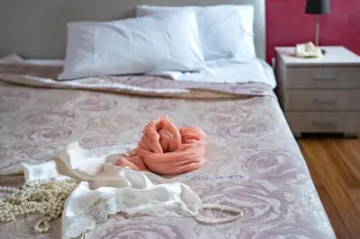 a bed with a pink towel on it with a dresser at B&B Pietre Preziose in Castelluzzo