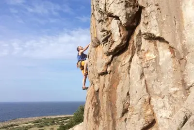 a man is climbing on a rock wall at B&B Pietre Preziose in Castelluzzo