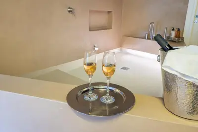 two glasses of wine on a tray in a bath tub at Palazzo Sant'Agostino in Palermo