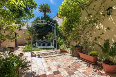 a garden with a blue gate and many plants at Palazzo Sant'Agostino in Palermo