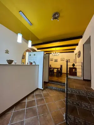 a kitchen and dining area of a house with yellow ceilings at Cut' Home in Monreale