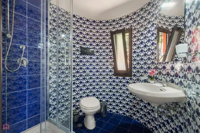 a blue and white bathroom with a toilet and a sink at Stunning seaview villa in Altavilla Milicia
