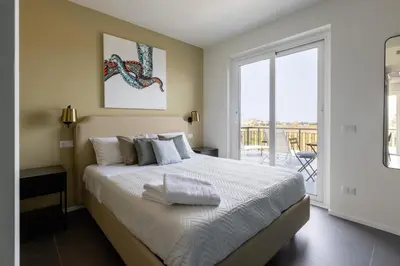a bedroom with a large bed and a balcony at Sweet Sicily Apartments in Carini