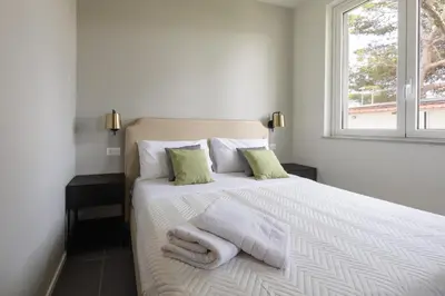 a bedroom with a white bed with towels on it at Sweet Sicily Apartments in Carini