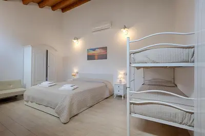 a bedroom with two bunk beds in a room at GuestHost - Il Piccolo Scrigno - Comfy & Central Studio x5 in Castellammare del Golfo