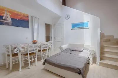 a bedroom with a bed and a table and chairs at GuestHost - Il Piccolo Scrigno - Comfy & Central Studio x5 in Castellammare del Golfo