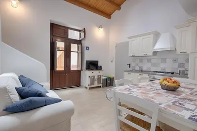 a kitchen and dining room with a table and a couch at GuestHost - Il Piccolo Scrigno - Comfy & Central Studio x5 in Castellammare del Golfo