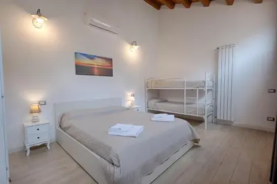 a bedroom with a bed and two bunk beds at GuestHost - Il Piccolo Scrigno - Comfy & Central Studio x5 in Castellammare del Golfo