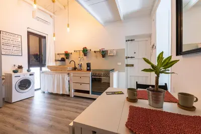 a kitchen with a washer and dryer in a room at ELLY HOLIDAY HOUSE in Palermo
