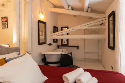 a living room with a red couch and a sink at ELLY HOLIDAY HOUSE in Palermo