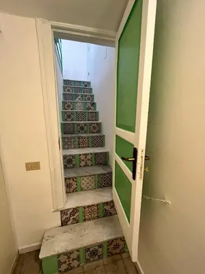 a stairway with a green door and some stairs at Mille Lire Peppe's Home in Palermo