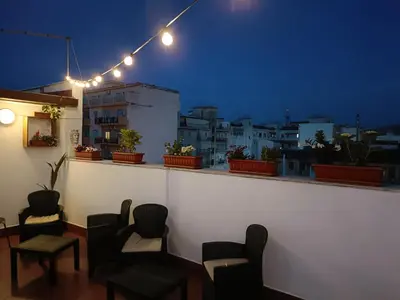 a rooftop bar with chairs and a view of a city at Mille Lire Peppe's Home in Palermo