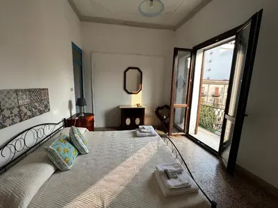 a bedroom with a large bed with a large window at Mille Lire Peppe's Home in Palermo