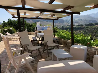 a group of chairs and tables under a pergola at Scopello Guidaloca Villas in Scopello