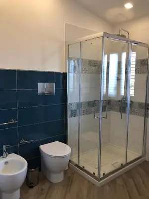 a bathroom with a shower and a toilet and a sink at Scopello Guidaloca Villas in Scopello