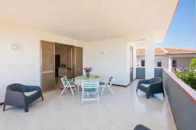 a patio with a table and chairs on a balcony at Villa Saracena in Castellammare del Golfo