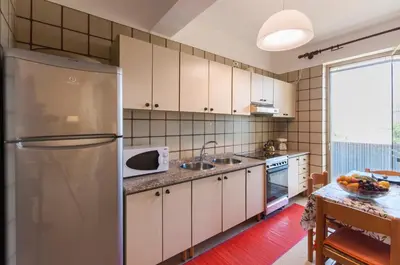 a kitchen with white cabinets and a refrigerator at Villa Saracena in Castellammare del Golfo