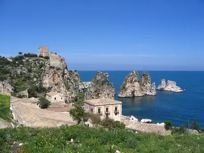 a building on a hill next to the ocean at Villa Saracena in Castellammare del Golfo