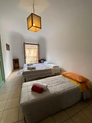 a room with three beds and a light fixture at Quiet and comfortable apartment in Palermo city centre in Palermo