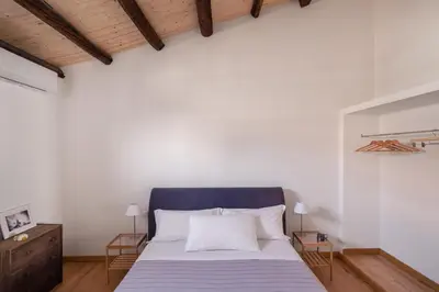 a bedroom with a bed with a blue headboard and white walls at Conte Ruggero Apartment by DomuSicily in Palermo