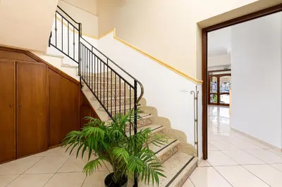 a staircase in a house with a plant at Hotel La Darsena in San Vito lo Capo