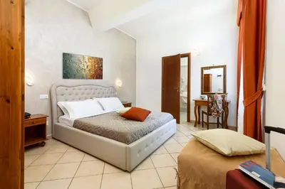a bedroom with a bed and a table in it at Hotel La Darsena in San Vito lo Capo