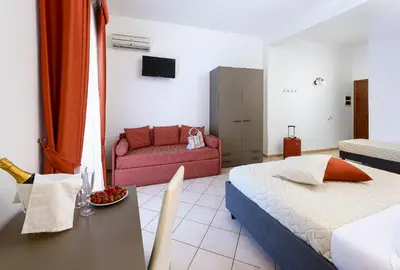 a hotel room with a bed and a couch at Hotel La Darsena in San Vito lo Capo