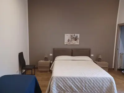 a bedroom with a large bed and a chair at GIORGISA in Palermo