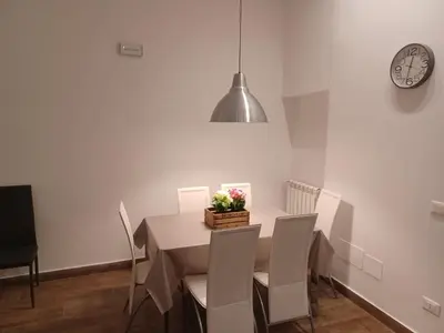 a dining room with a table and chairs and a clock at GIORGISA in Palermo