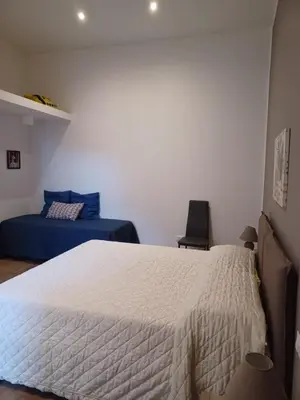 a bedroom with a white bed and a blue bed sidx sidx sidx at GIORGISA in Palermo