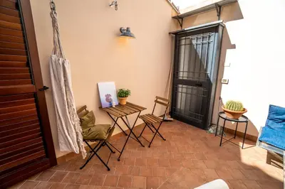 a balcony with chairs and a door and a table at Solemar Sicilia - Palazzo Vetrano Centro Storico in Palermo