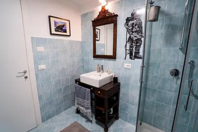 a blue tiled bathroom with a sink and a shower at Solemar Sicilia - Palazzo Vetrano Centro Storico in Palermo